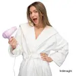 lady in robe holding a blow dryer