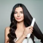 lady showing how to curl your hair using a flat iron
