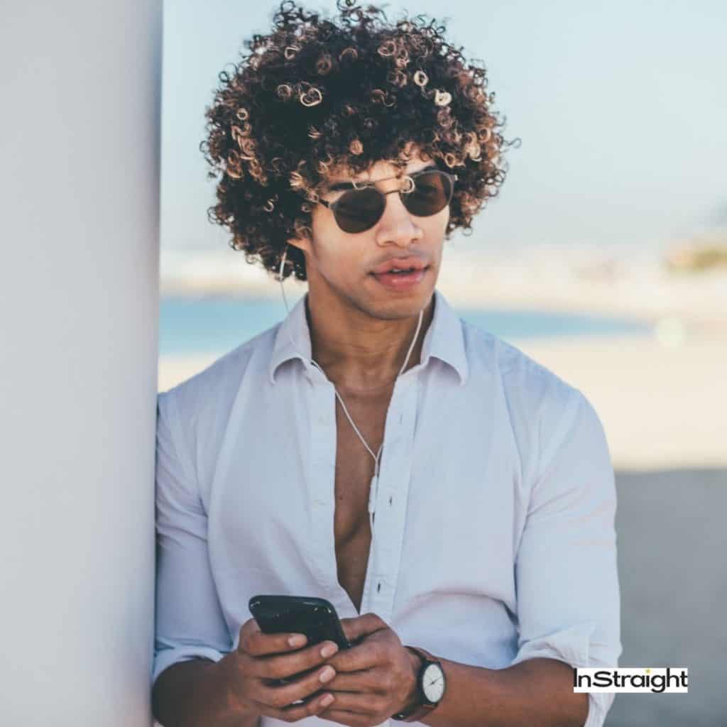A man in sunglasses showing his curly hair after curly hair blowout men