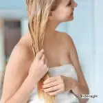 blonde lady adding conditioner to her hair