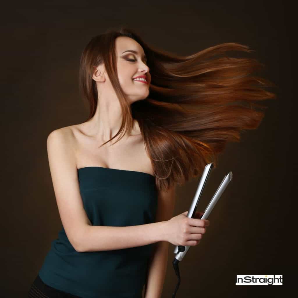 pretty lady with long, dark, straight hair holding a hair straightener
