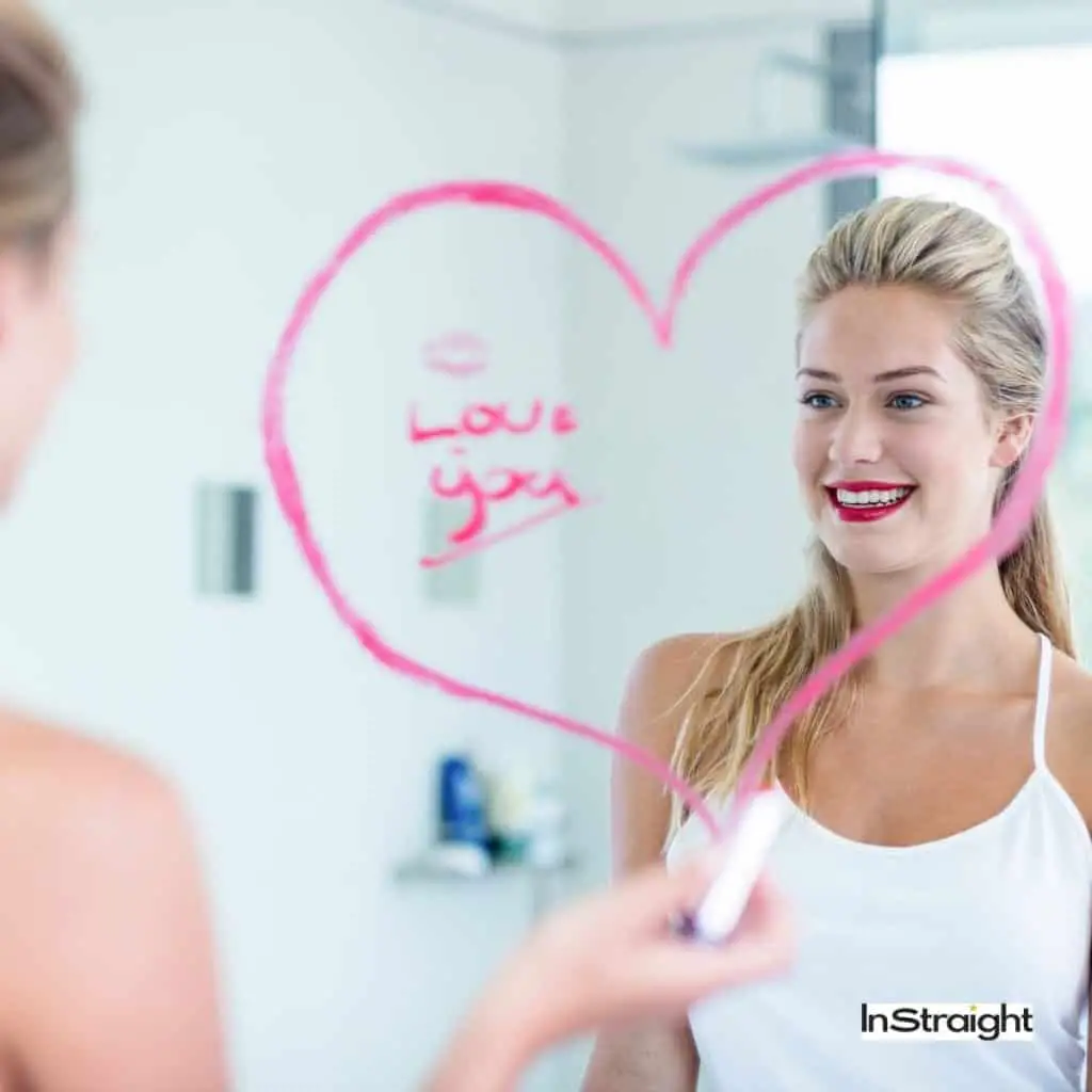 lady writing love you on the bathroom mirror