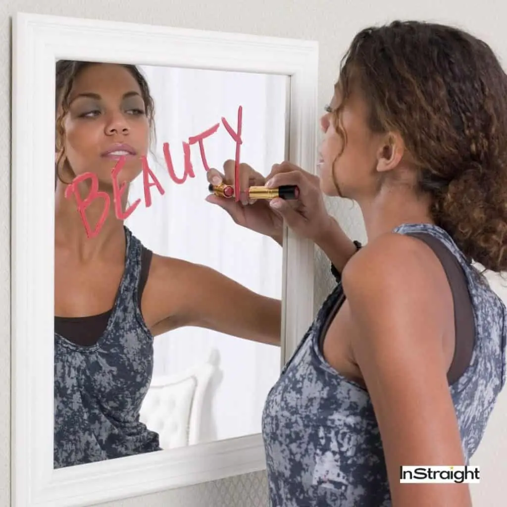 African woman writing on bathroom mirror