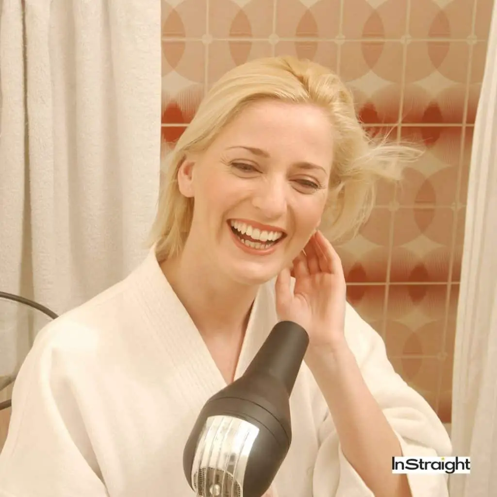 blonde lady blow drying her hair