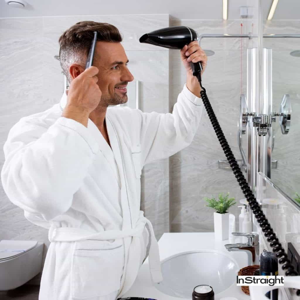 man drying his hair in the bathroom