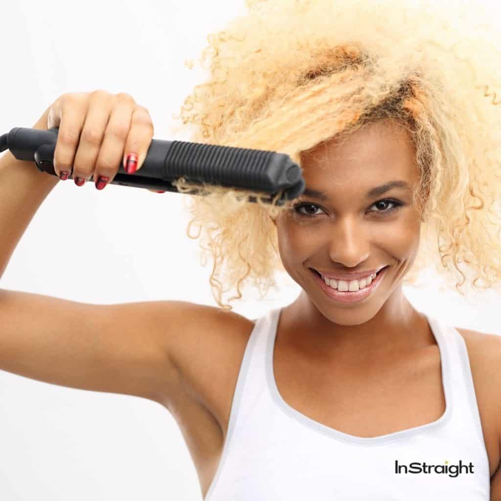 lady using a steam hair straightener to straighten her curly hair