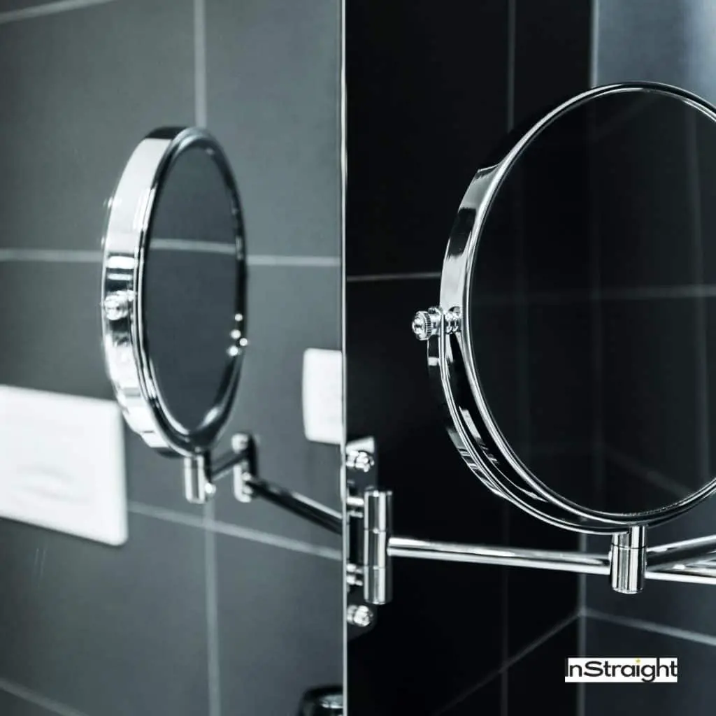 pivot mirror in a black themed bathroom under title What Type of Mirror is Used in Bathrooms
