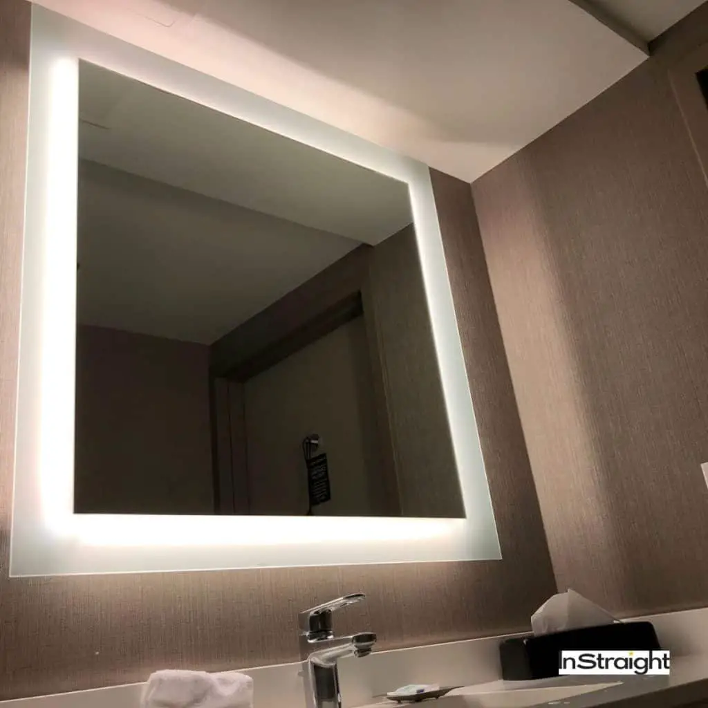 A backlit mirror on top of a sink under title Are Backlit Mirrors Good for Makeup?