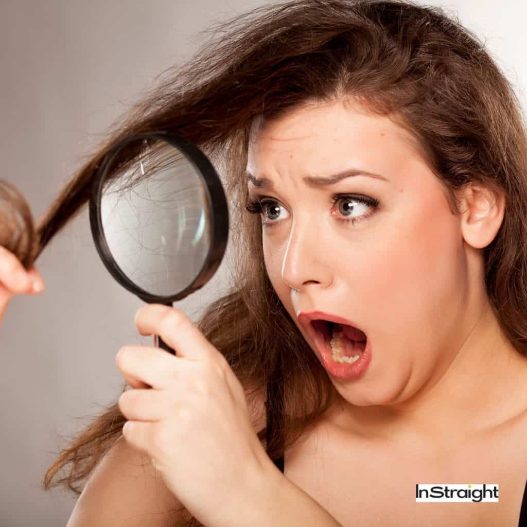 A lady checking her damaged hair under a lens 