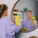 women removing dust but how to clean a mirror spotless